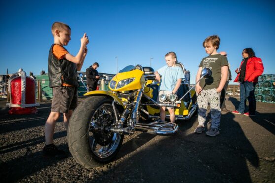 River, Lauchlan and Leland Simpson eye up one of machines on show at Arbroath. Image: Kim Cessford/DC Thomson