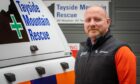 Paul Russell standing next to Tayside Mountain Rescue vehicle