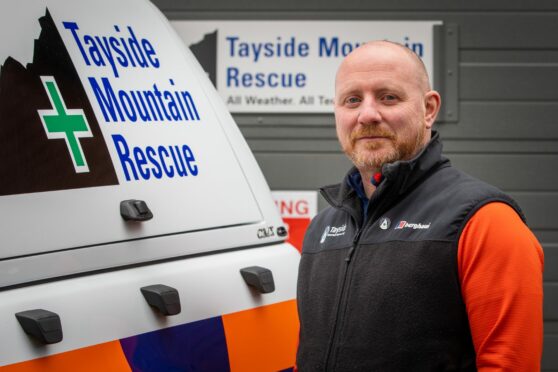 Paul Russell standing next to Tayside Mountain Rescue vehicle
