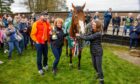 One of the owners Thomas Kendall celebrates with Lucinda Russell and stable girl Lauren Walsh with the trophy alongside the winning horse Coach Rambler after he returned home to the Lucinda Russells Stables in Milnathort.