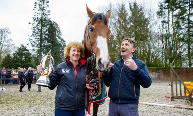 Winning trainer Lucinda Russell poses with the Grand National trophy alongside partner Peter Scudamore after the win by Corach Rambler. Image: Kenny Smith/DC Thomson.