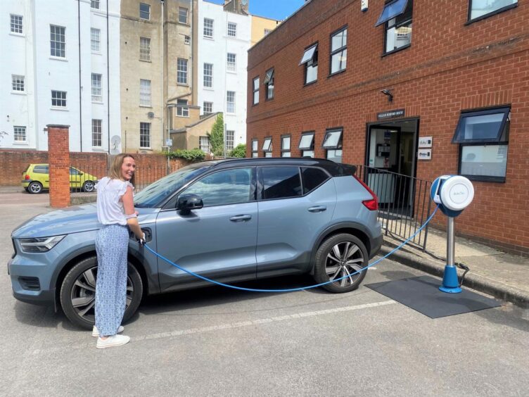 Helen holding an electric car charger during accessibility trials for the new Dundee charging hub. 