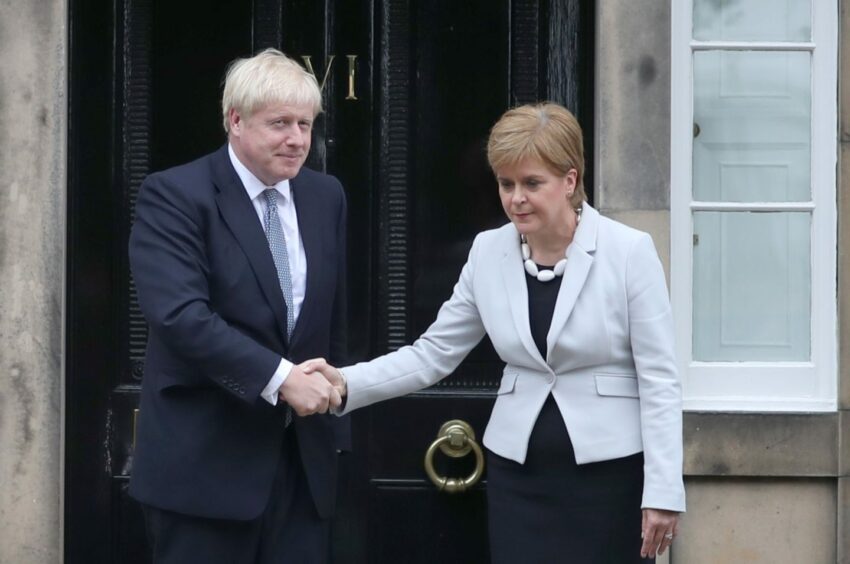 Unsmiling Nicola Sturgeon shaking hands with Boris Johnson on the steps of Bute House.