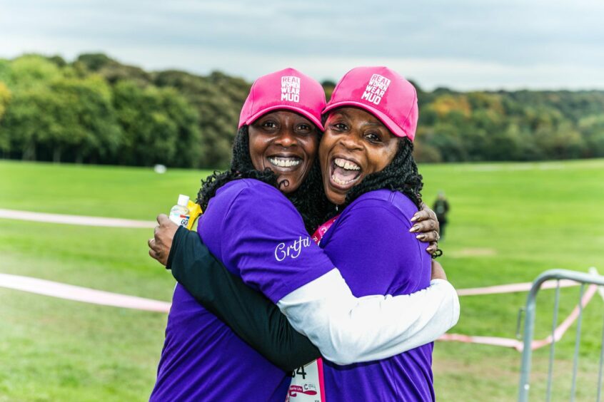 Two runners hugging after completing a Race for Life event in Dundee.