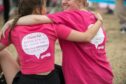 Two runners sat hugging after running Race for Life in Dundee.