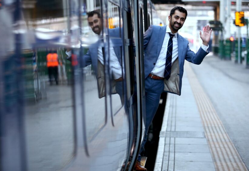 Humza Yousaf waving from a train door.