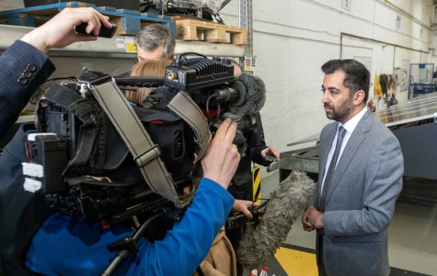 Humza Yousaf speaks to reporters and camera crews