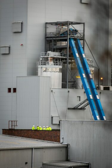 Workers looking on from the nearby biomass plant.