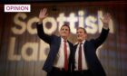 Scottish Labour leader Anas Sarwar and national party leader Keir Starmer waving from a stage in front of a large Scottish Labour banner