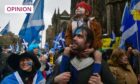 A man with a small boy on his shoulders walk throw a rally of independence supporters in Edinburgh.