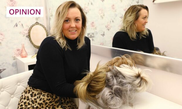 Karen Ward holding wigs in a hair salon