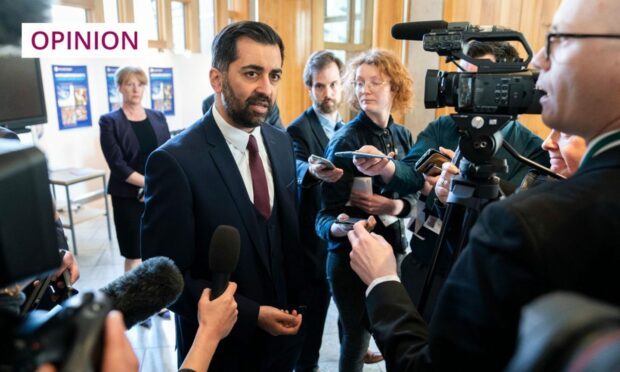 Humza Yousaf surrounded by journalists at the Scottish Parliament.
