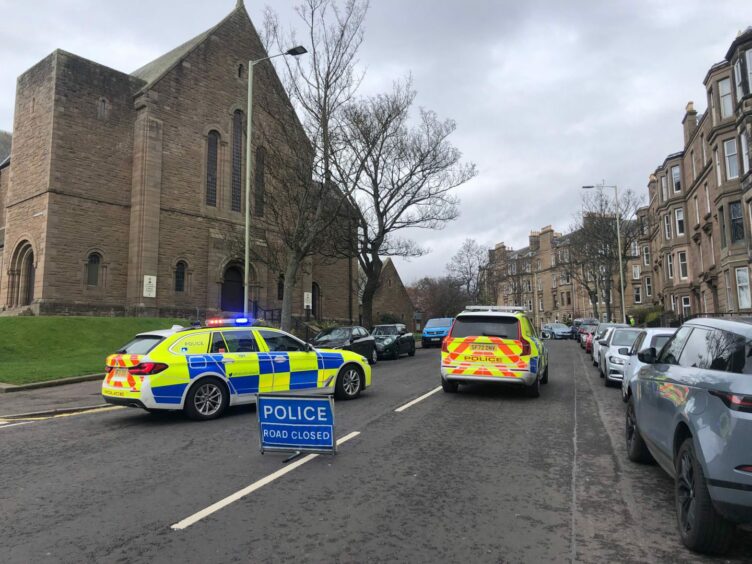 Police cars and 'road closed' sign on Blackness Avenue after the car crash.