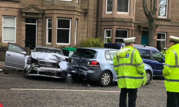 Two bashed up cars and police officers at the scene of the crash on Blackness Avenue in Dundee.