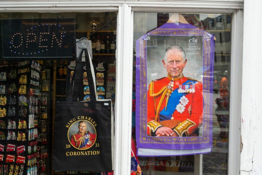 Windsor shop window display featuring King Charles coronation tea towels, tote bags and fridge magnets