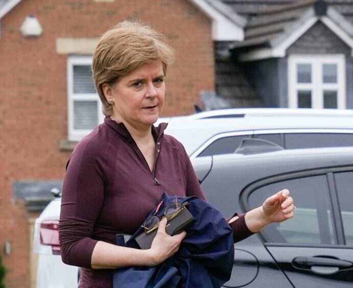 Nicola Sturgeon leaving her home with a stern expression.