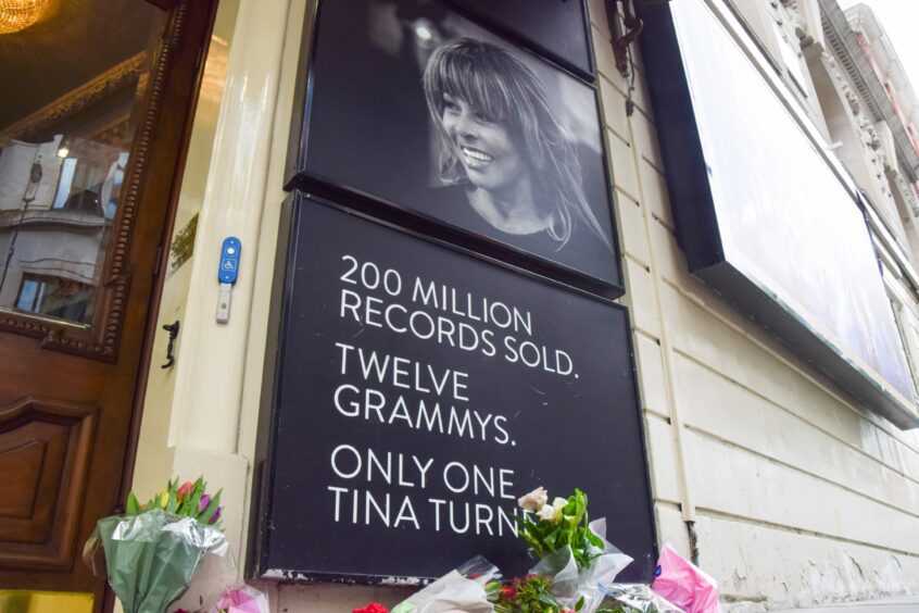 Flowers outside a theatre, where the billboard reads '200 million records sold, 12 Grammies, only one Tina Turner'.