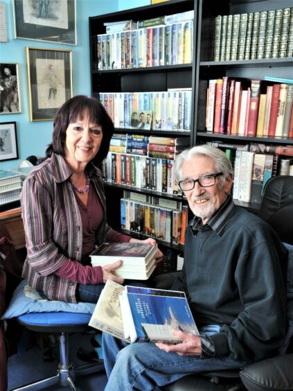 Writers and actors Lesley Mackie and Terry Wale in their study filled with books, c. 2018. Image supplied by Lesley Mackie.