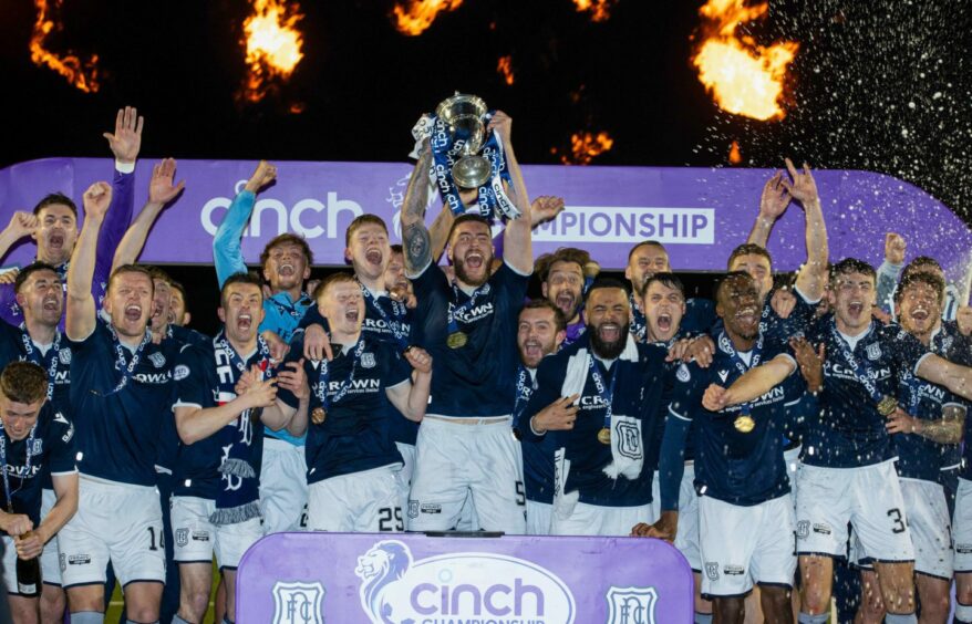 Dundee captain Ryan Sweeney lifts Championship trophy as team-mates celebrate after title win over Queen's Park.