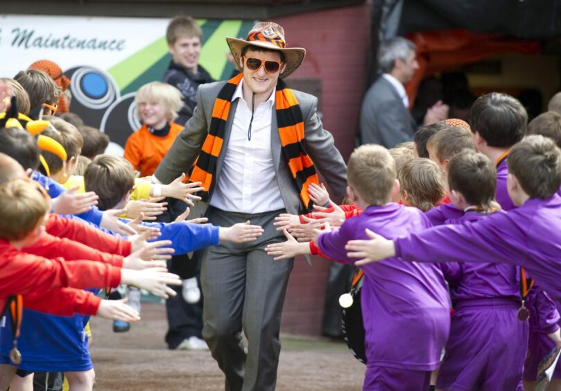 Conway is welcomed back to Tannadice by a group of youngsters. Image: SNS.