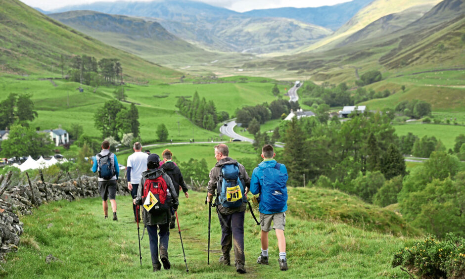 People in hiking gear walking through countryside near Blairgowrie