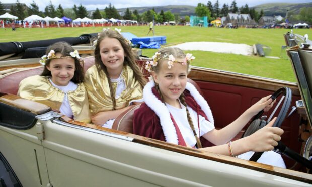 Gala Queen Evie Head at the wheel of a vintage Alvis with attendants Ellie Robertson and Emily Gordon at Blackford Highland Games. Image: Phil Hannah.