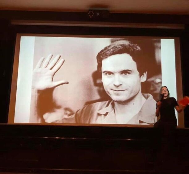 Cheish Merryweather on stage talking about notorious serial killer Ted Bundy. Image: Crime Viral. 
