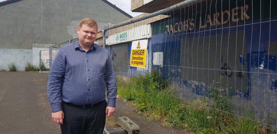 Councillor Daniel Coleman standing outside the derelict former shops