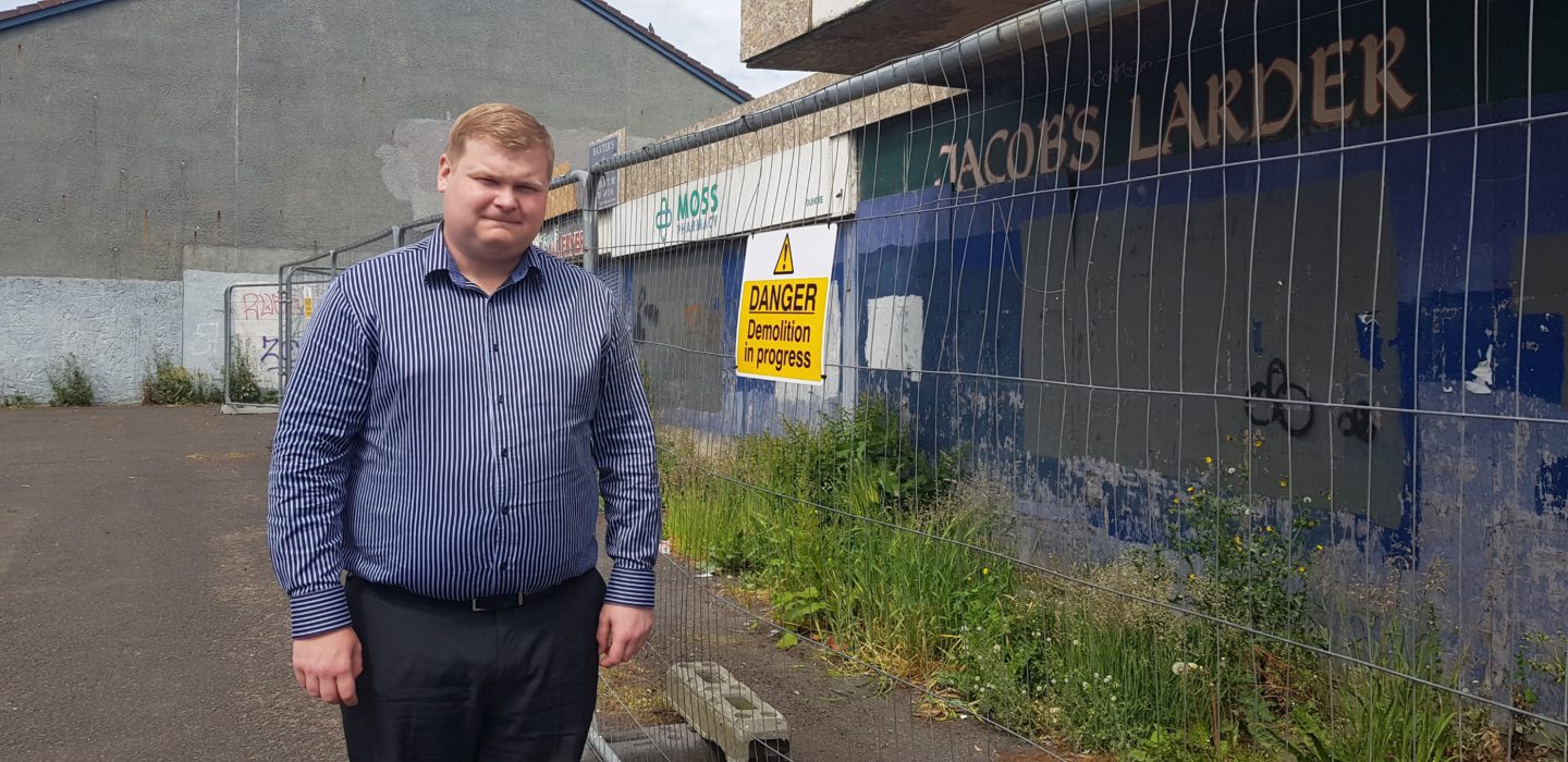 Councillor Daniel Coleman is standing outside the derelict former shops