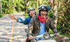 Senior couple happily riding a classic scooter, showing they're ready for retirement