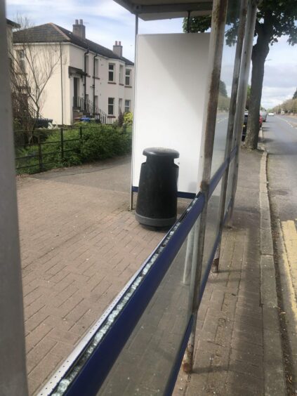 A bus shelter in Dundee with a glass panel missing