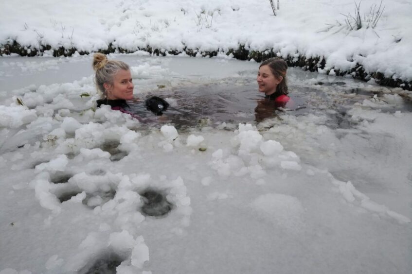 Hannah Charles swimming in an icy pond with her mum Sarah. The cold water helps her chronic fatigue syndrome symptoms. Image: Submitted by Hannah Charles. 