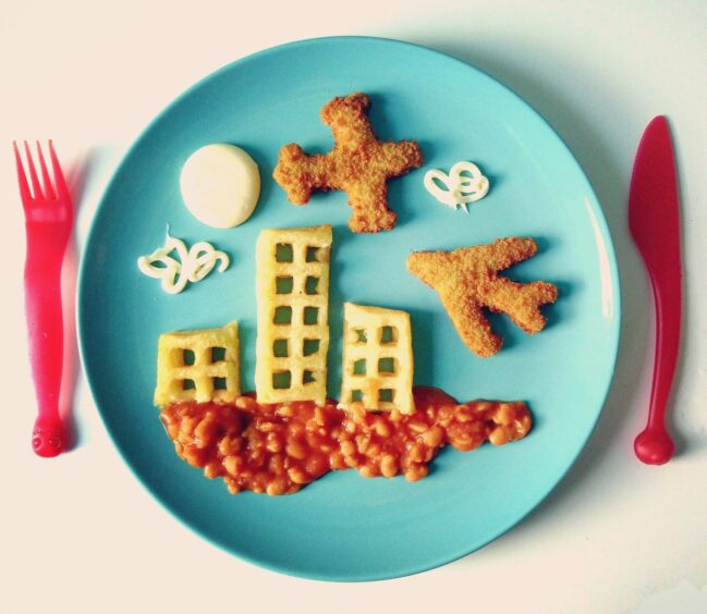 'In-flight meal'. A city-scape with planes and buildings. Image: Hugh Raine.