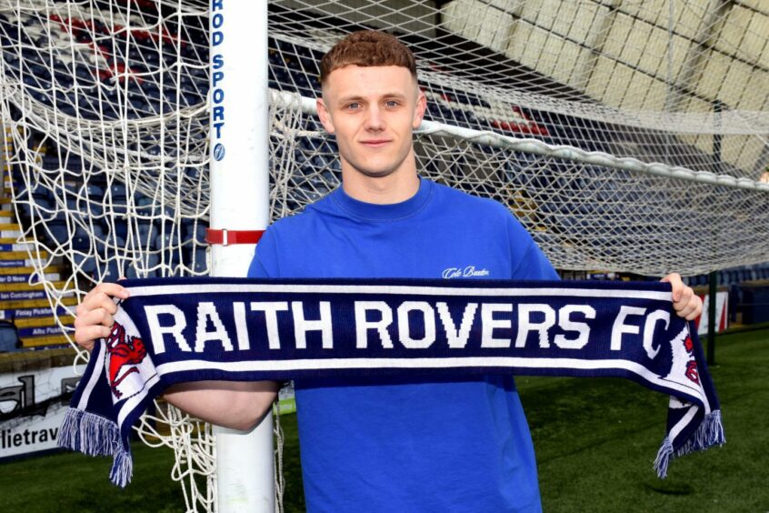 Jack Hamilton, holding a scarf and standing beside the goals, has signed for Raith Rovers.