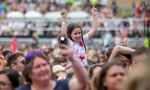 A girl on an adult's shoulders enjoying music at Radio 1's Big Weekend in Dundee
