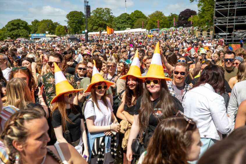Women with traffic cone hats enjoy the Big Weekend in Dundee.