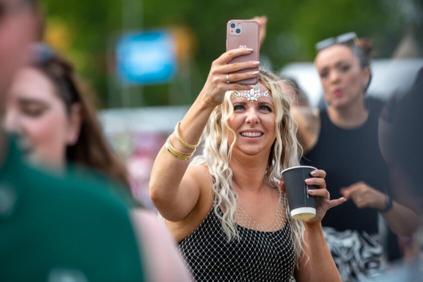 Reveller takes photo during final day of Big Weekend.