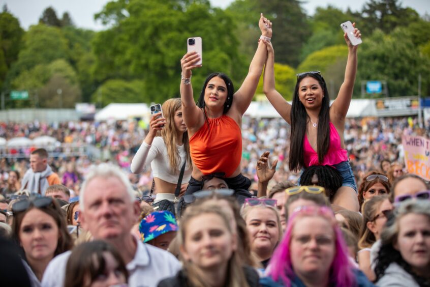 Fans are held aloft to take in a better view of the main stage.