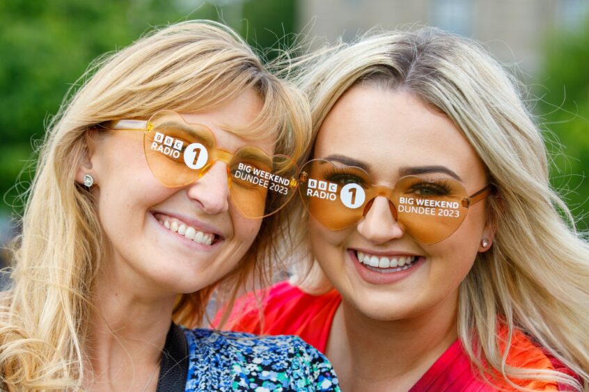 Hannah Smith and Marisa Mulraine sporting Big Weekend branded sunglasses as the wait on their bus. 