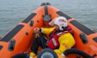 The stranded dog in the safe hands of crew member, Robert Rutherford. Image: Kinghorn RNLI