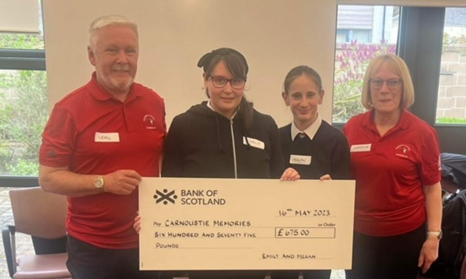 Craig Murray and Lorraine Young of Carnoustie Memories receive the cheque from Emily and Megan