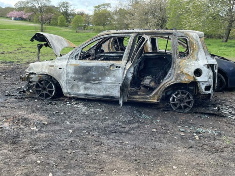 A side view of a burnt-out car at Caird Park in Dundee