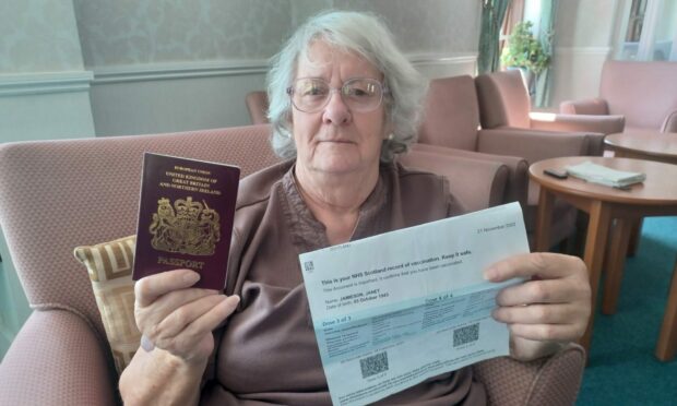 Janet Jamieson with her passport and proof of her third and fourth Covid vaccinations.