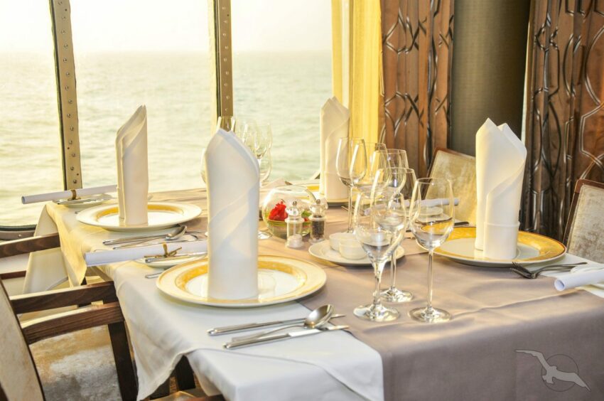 A table set for dinner with a view of the sea