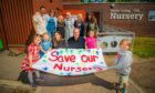 Union reps, Pete Wishart MP, nursery staff and children holding a banner outside the nursery. The banner says "save our nursery"