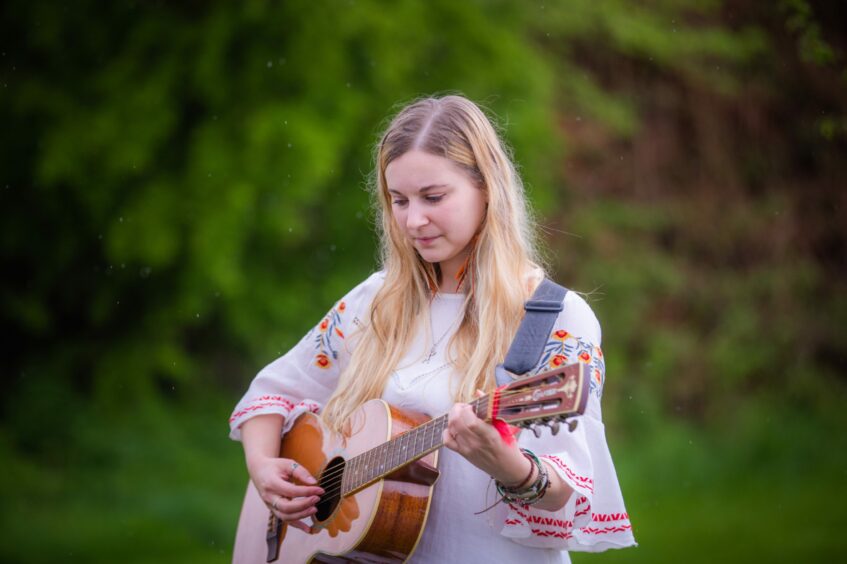 Hannah, who plays the guitar, finds positivity in her music. Image: Steve MacDougall/DC 