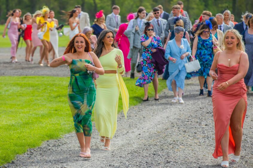 Scenes capturing many people walking around the grounds of Perth Racecourse.