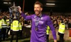 Dundee goalkeeper Adam Legzdins celebrates winning the Championship at Ochilview. Image: PA