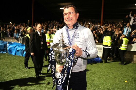 Former Dundee manager Gary Bowyer celebrates with the Championship trophy. Image: PA.