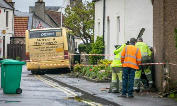 Engineers assess the damage to an electrical box reported to have been damaged in the earlier Freuchie bus crash. Image: Steve Brown/DC Thomson
